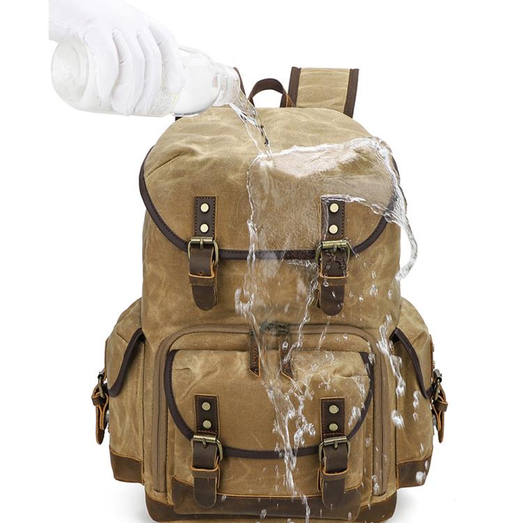 Mochila fotográfica retro de lona encerada con doble correa para cámara sin espejo y portátil.